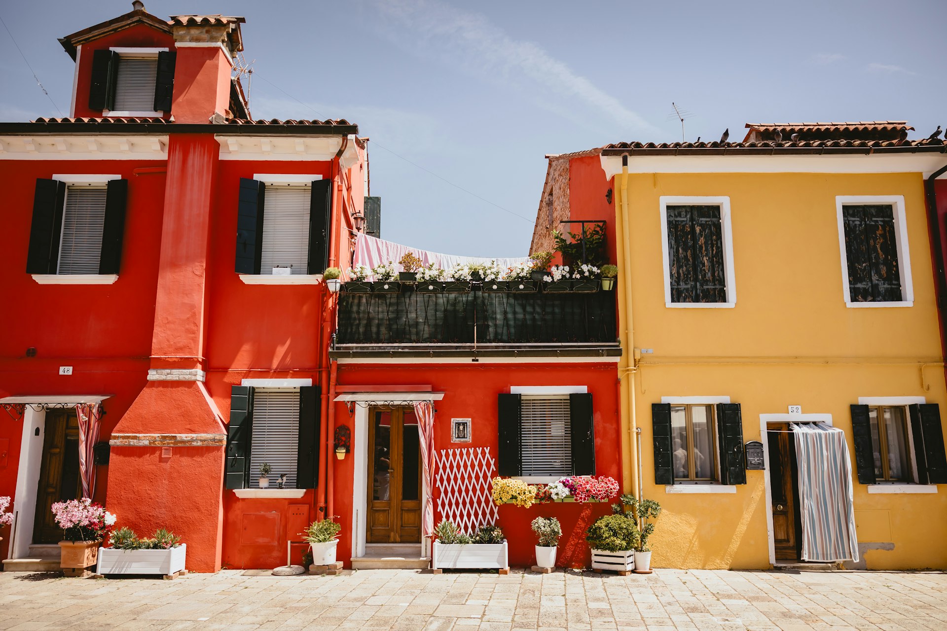 Brightly colored houses stand under a clear blue sky.
